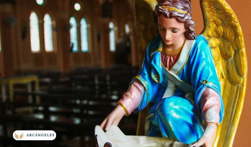 Imagen de una estatua de un arcángel en una iglesia, simbolizando la presencia divina y la protección espiritual. El arcángel está vestido con ropas celestiales de tonos azules y dorados, y sostiene un pergamino en sus manos, representando la transmisión de bendiciones y mensajes divinos.