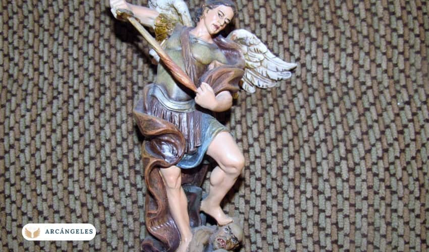 Escultura del Arcángel Miguel, figura bíblica, pisoteando la cabeza de un demonio.