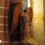 Estatua del Arcángel Gabriel en el interior de una iglesia, representado con alas doradas y vestimenta ceremonial, símbolo de guía y luz divina