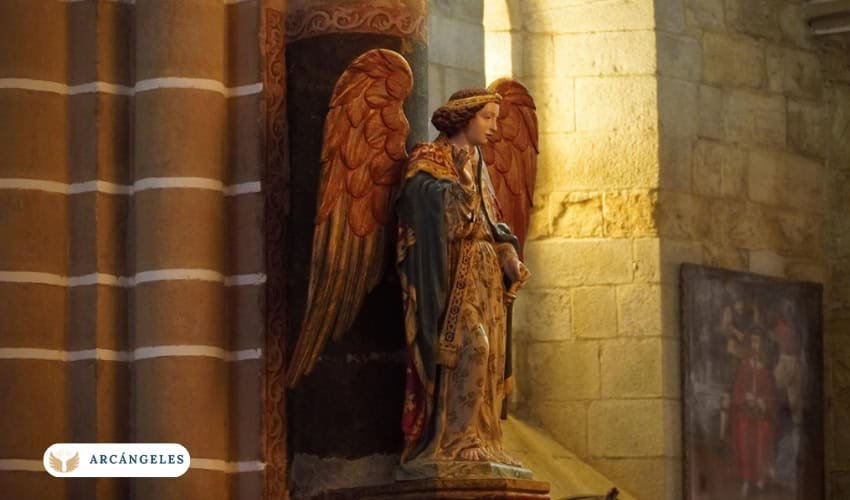 Estatua del Arcángel Gabriel en el interior de una iglesia, representado con alas doradas y vestimenta ceremonial, símbolo de guía y luz divina