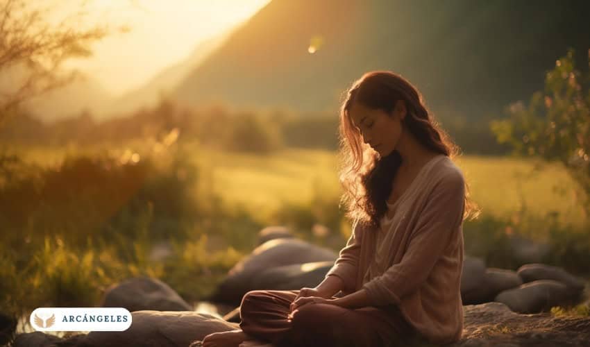 Persona meditando al aire libre al atardecer, conectando con la naturaleza y buscando paz espiritual en un entorno tranquilo, ideal para la meditación con Dios y los arcángeles.