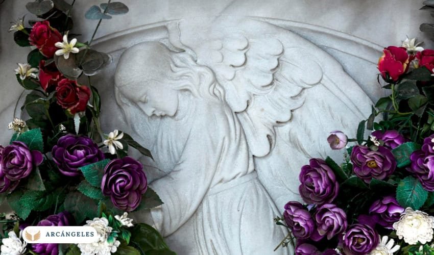 Imagen de un relieve de San Miguel Arcángel rodeado de flores moradas y rojas, símbolo de ofrendas y devoción espiritual.